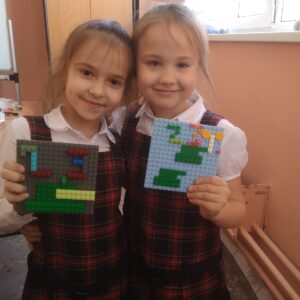 на фото дети демонстрируют открытки к 23 февраляиз лего